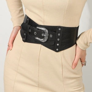Detail of vintage carved metal buckle and rivets on black elastic wide waist belt