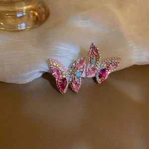 Detailed macro shot of sparkling butterfly stud earrings with colorful rhinestones