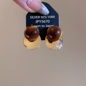 Detailed close-up of 18k gold plated bird earrings with tiger eye stone and 925 silver needle