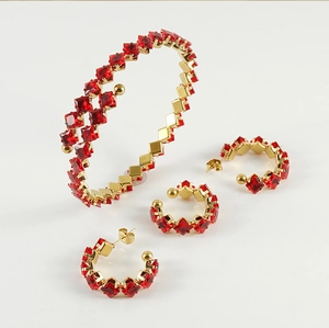 Detailliertes Goldschmuck-Set mit quadratischen roten Edelsteinen auf weißem Hintergrund