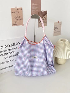 Detail of purple gingham tote bag with pink bow prints and Sozakka woven label