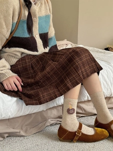 Detail of beige crew socks with cute bear embroidery and brown velvet Mary Jane shoes