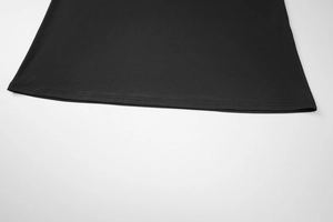 Detail des doppelt genähten Saums und der elastischen Stoffstruktur eines schwarzen Kleides
