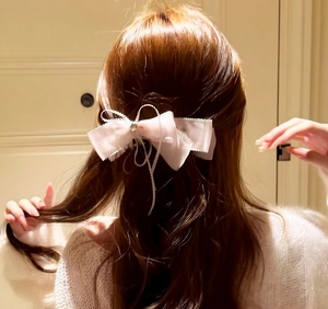 Gros plan d'une élégante pince à cheveux noeud en dentelle avec étoile sur cheveux bruns