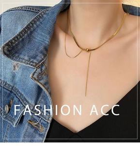 Macro detail of gold-plated double-layered snake chain and pendant worn by model