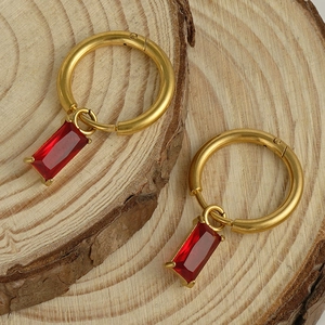 Gros plan de boucles d'oreilles créoles dorées 18K avec pendentifs zircon rouge rectangulaire