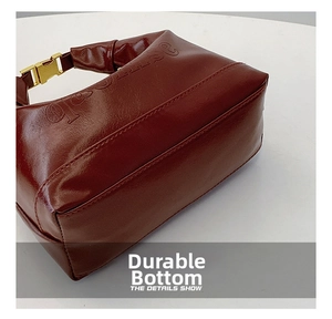 Detail of dark red vintage pillow bag showing stitching and reinforced bottom base