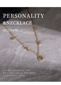 Close-up of golden sterling silver necklace featuring lock pendant and key charm with crystals