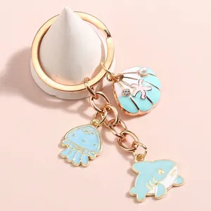 Ocean themed keychain with blue shell, jellyfish, shark charms and pearl on gold ring