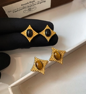 Gros plan de boucles d'oreilles œil de tigre vintage avec cadres en losange doré