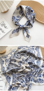 Detail of blue and white paisley silk scarf with smooth satin texture and elegant drape
