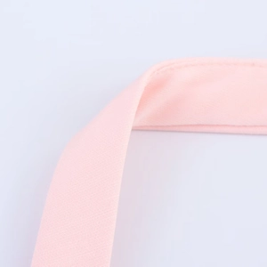 Close-up of light pink bow halter top showing smooth fabric texture and seam detail