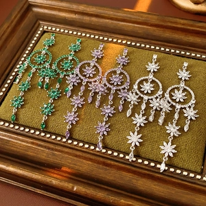 Detailed view of floral tassel earrings in green purple and white with sparkling zircons