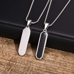 Detailed shot of geometric stainless steel bar pendants on a textured jewelry box