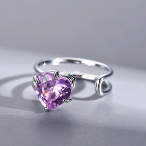 Macro shot of a silver open ring featuring a large heart-shaped purple zircon stone