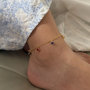 Chic gold ankle bracelet with colorful heart charms on a woman's ankle for beach style
