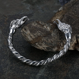 Retro Viking stainless steel twisted bangle featuring silver wolf head ends on black rock