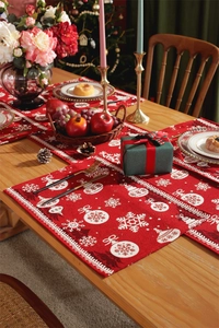 Close-up of red Christmas table runner with white snowflake and bauble jacquard patterns