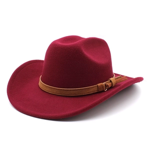 Détail d'un chapeau de cow-boy en feutre bordeaux avec bande en cuir brun et boucle métal
