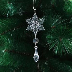 Transparent crystal snowflake ornament with faceted teardrop pendant on a Christmas tree