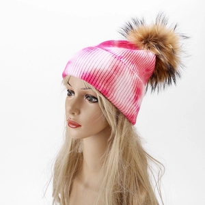 Macro shot of pink and white gradient knit texture with soft faux fur pompom detail