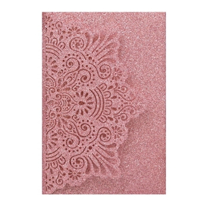 Macro detail of laser-cut mandala pattern on pink glitter wedding invitation cover