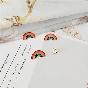 Detailed view of rainbow enamel pins with gold finish and butterfly clutch backing