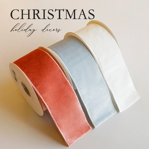 Three rolls of luxury velvet Christmas ribbons in brick red, grey blue and cream white