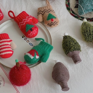 Charming knitted Christmas tree ornaments including mini gloves and pine cones in festive colors