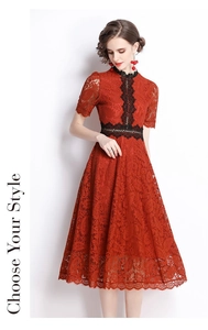 Close-up of red lace dress with intricate embroidery and black floral trim details