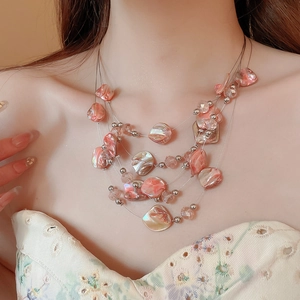 Close-up of multilayer shell and crystal bead necklace showing texture and pearlescent details