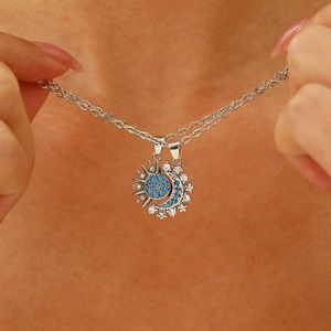 Detail of moon and sun pendants with blue cubic zirconia on a delicate silver chain