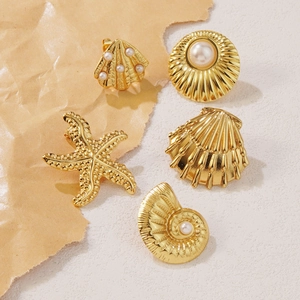 Golden starfish and seashell earrings with pearls on a vintage beach-themed background