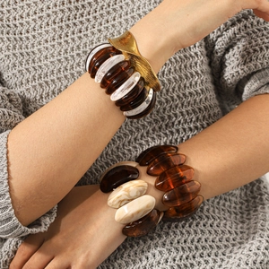 Vintage amber resin bangles with gold leaf accents on a grey knit sweater sleeve