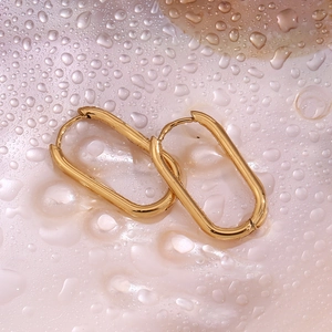 Macro shot of 18K gold plated oval hoop earrings with a mirror finish and water drop decor