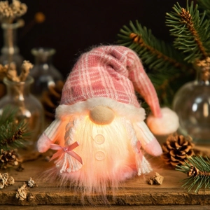 Detail of a glowing pink Christmas gnome with LED lights and knitted sequin hat decor