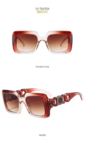Detail of oversized square sunglasses with gradient tea lenses and gold chain-style temples