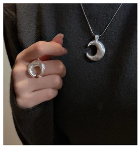 Detail of S925 sterling silver crescent ring and necklace with hammered texture finish