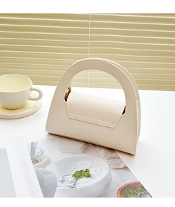 Chic beige lychee pattern mini handbag shown with a book and coffee in natural light
