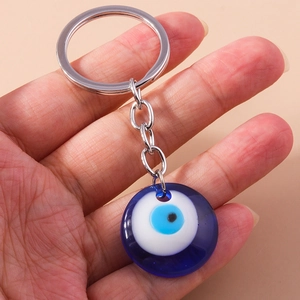 Macro shot of a deep blue Evil Eye charm on a polished silver keychain for bags