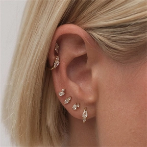 Close-up of model wearing gold S925 silver ear cuff and stud set with shiny cubic zirconia