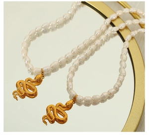 Detailed view of natural freshwater pearl necklace with vintage gold snake pendant