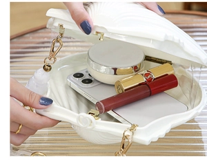 Detail of white shell evening bag interior with gold chain and large capacity storage