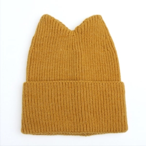 Detail of mustard yellow cat ear knit beanie featuring classic ribbed texture and soft fabric