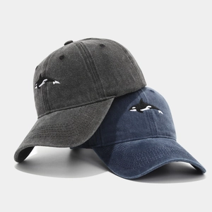 Washed cotton baseball caps in dark grey and navy featuring detailed orca embroidery