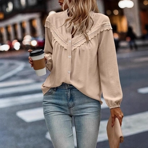 Close-up of elegant apricot blouse featuring intricate lace details and V-neckline