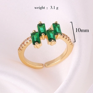 Adjustable gold ring with green rectangle zircons shown on silk with size specs