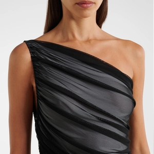Detail of ruched black mesh fabric on a one-shoulder swimsuit with elegant pleats