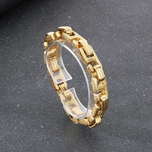 Detailed close-up of interlocking gold Cuban chain links with textured brushed finish