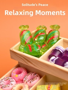 Miniature resin candy, donut, and purple jam jar accessories on an orange background